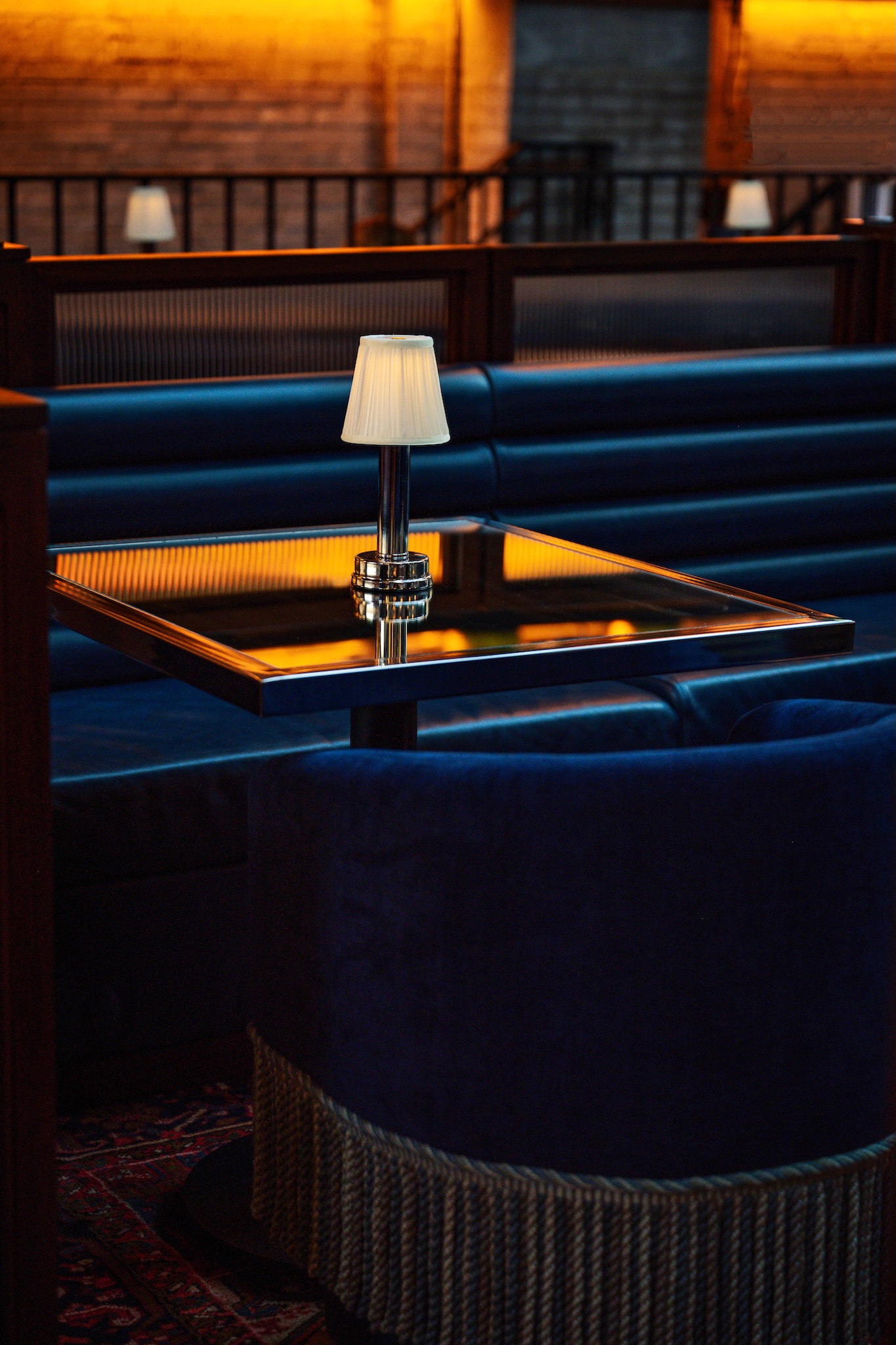 Glass table and blue velvet club chair at Civil Works