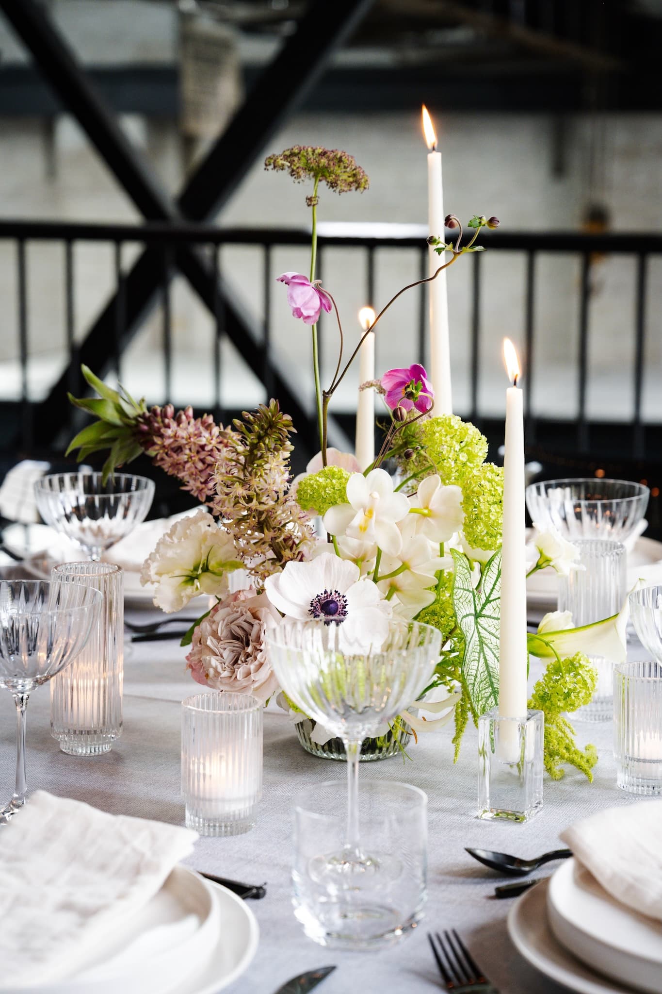 Beautiful floral arrangement and taper candles in the middle of a table.