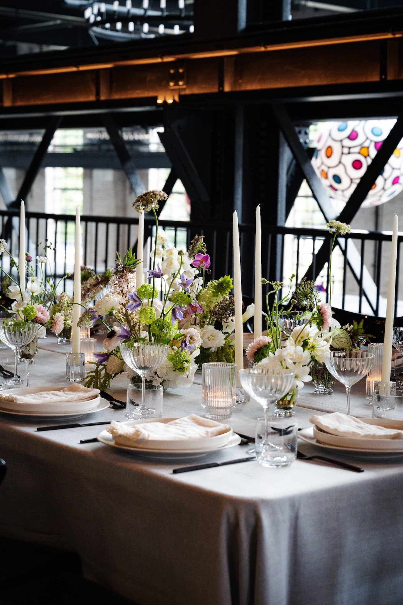 Close up of flowers and dinnerware on a table set for a formal dinner