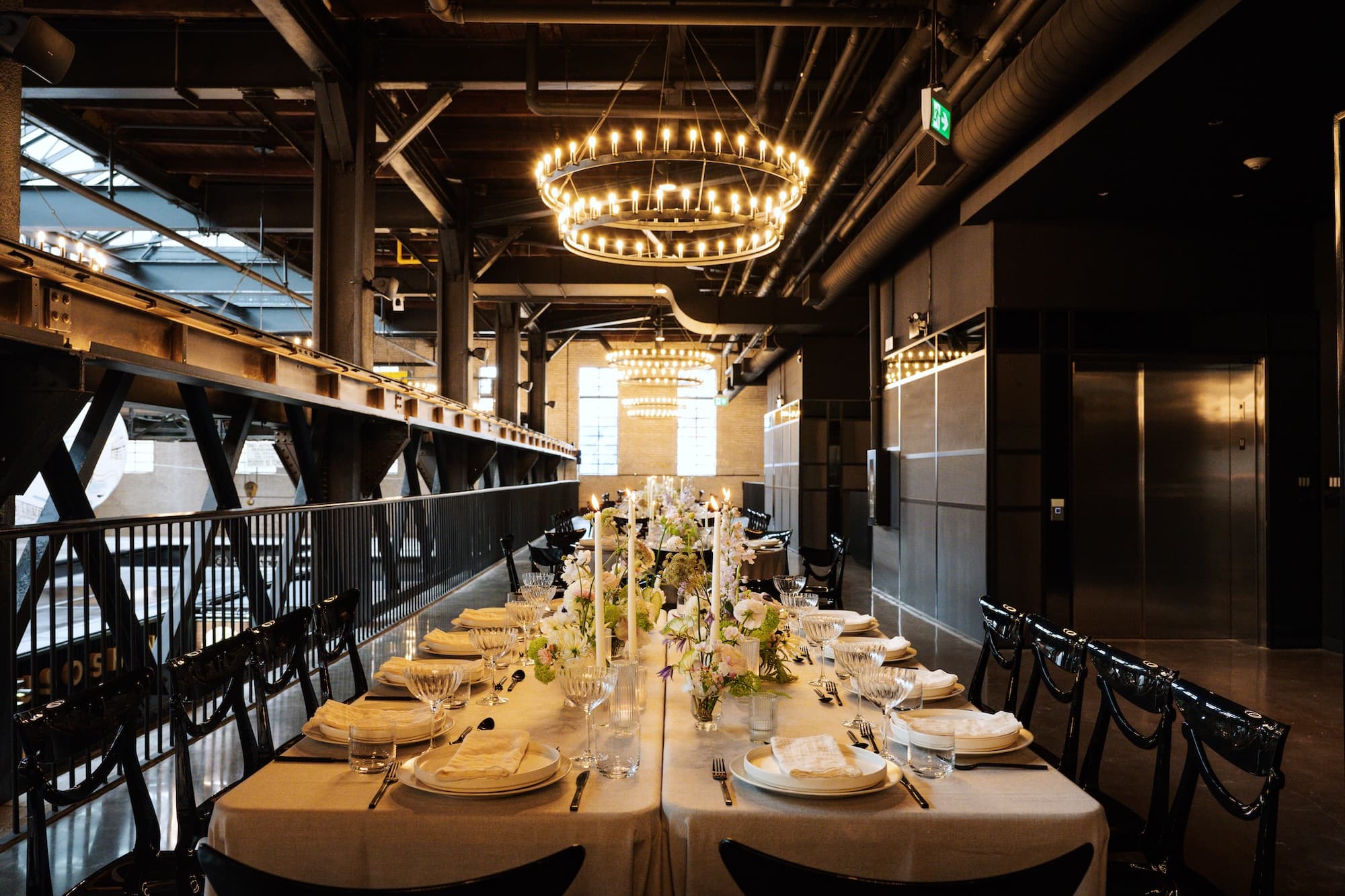 West Hall event space set up for a formal dinner, showing four long rectangular tables end to end.