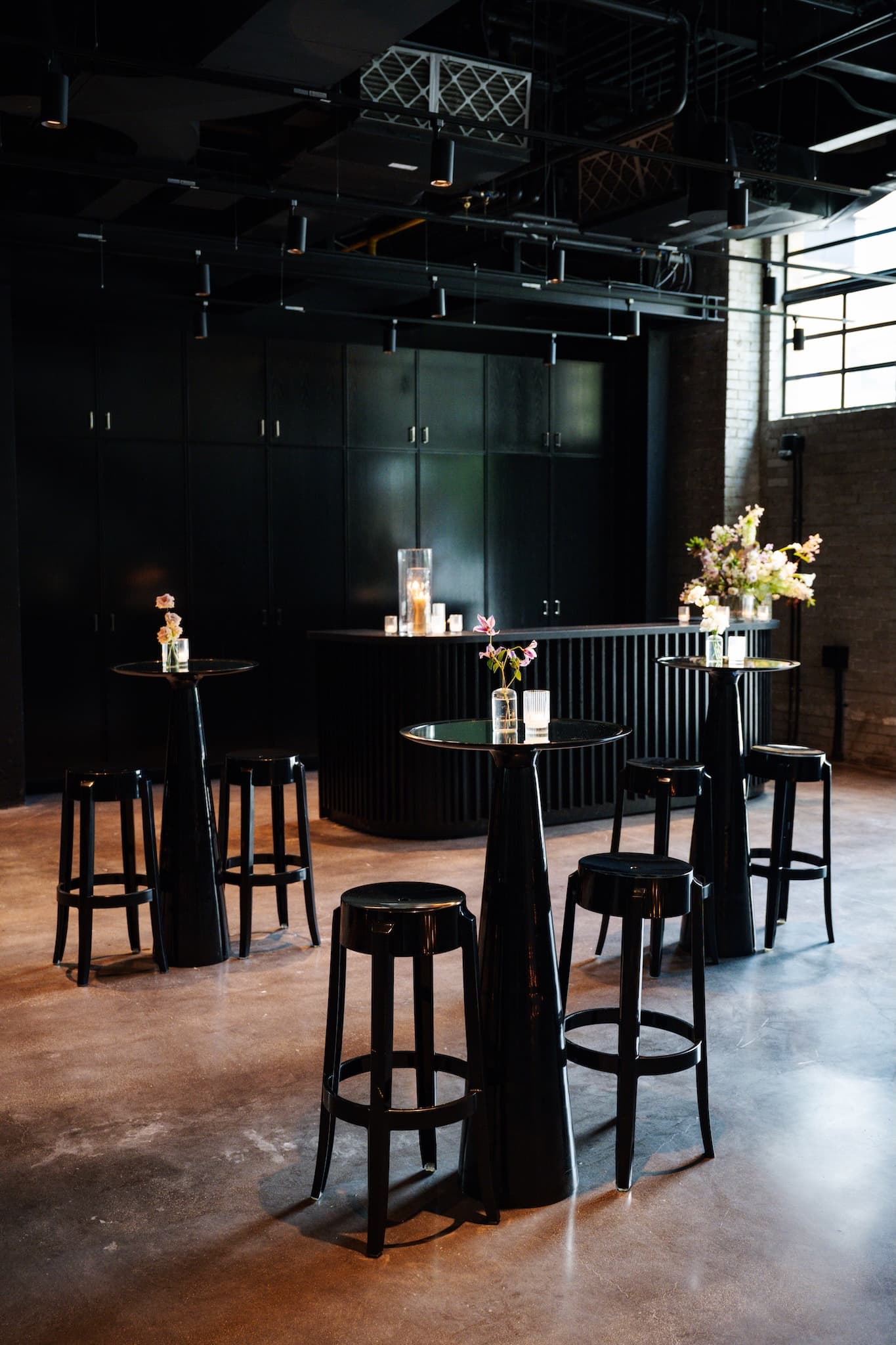 Black cruiser tables and black stools set for a cocktail party