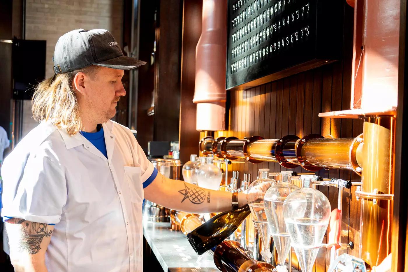 Nick Kennedy of Civil Works pouring remineralized water into a bottle at the bar