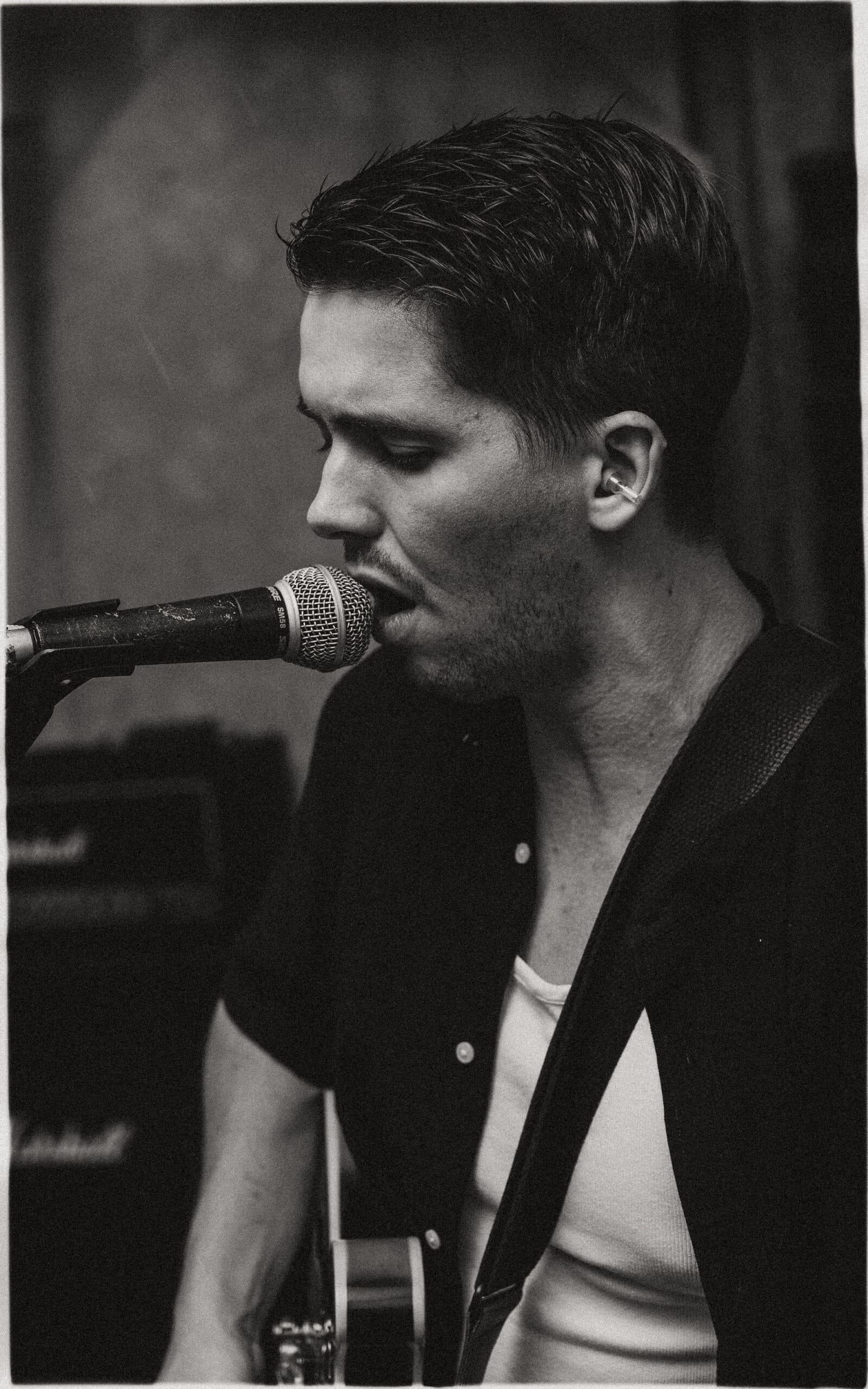 Songwriter Zack Erickson singing a song while playing his guitar.