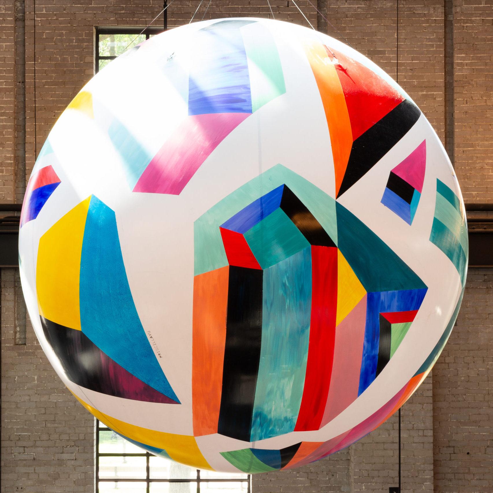 A large painted globe, of colourful jewel like shapes, hanging high from the food hall rafters.