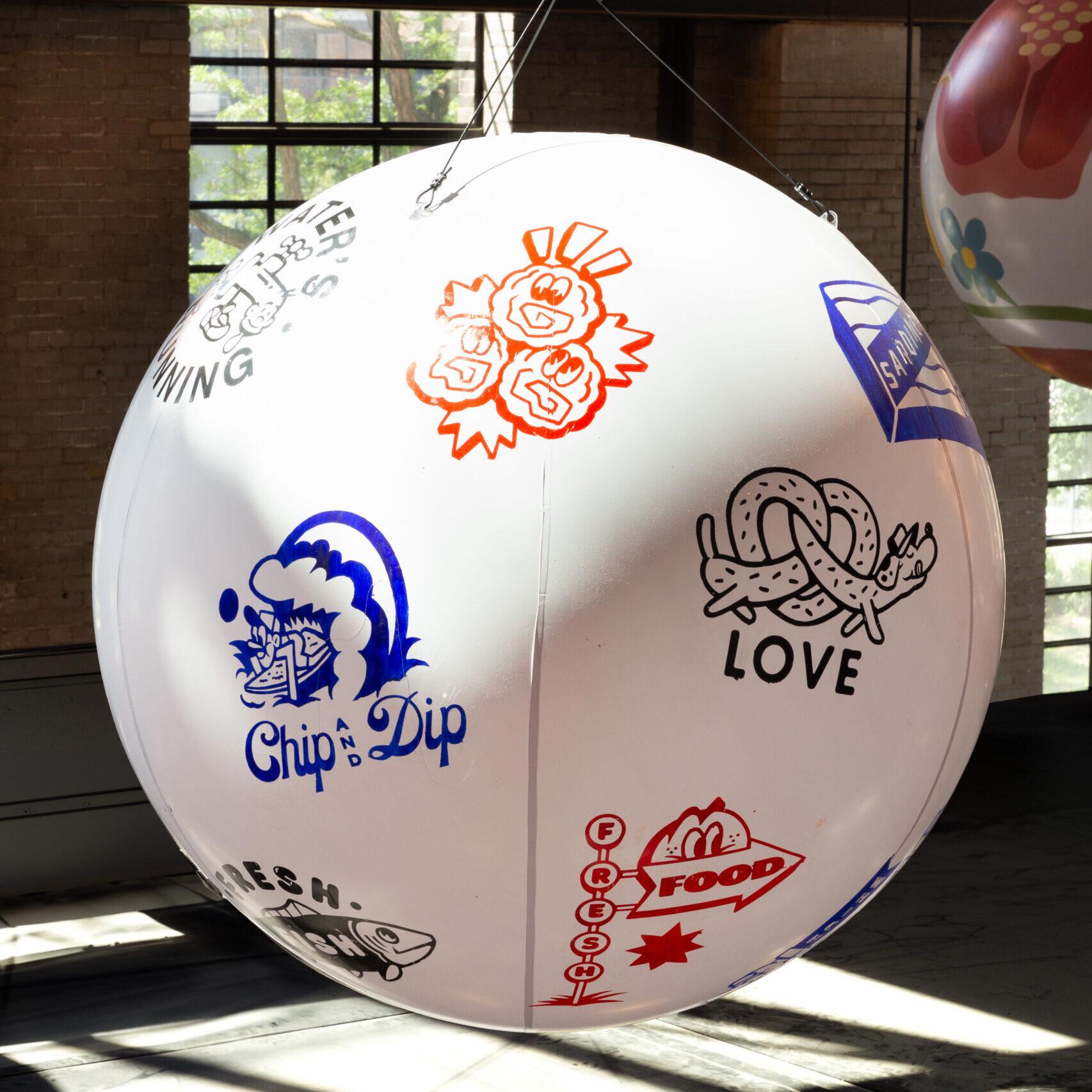 A painted globe of pop art hanging from the rafters of the food hall.