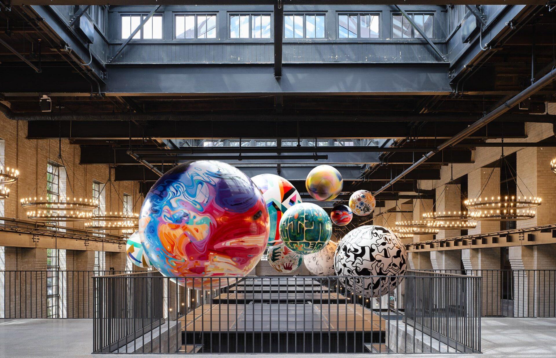 Looking westbound from the Mezzanine level of the food hall, the photo shows several colourfully painted spheres suspended over the food kiosks.