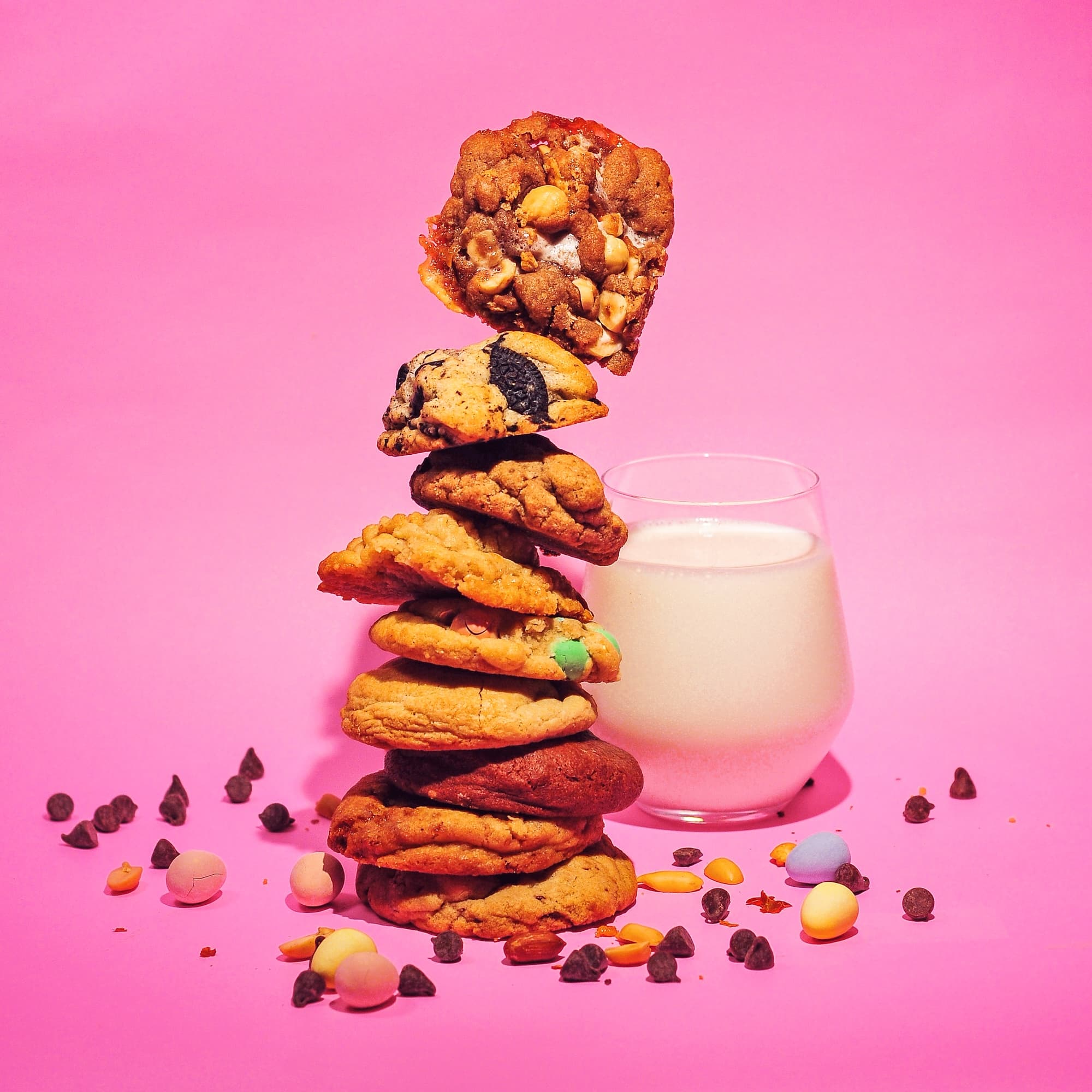 Stack of different types of cookies and a glass of milk