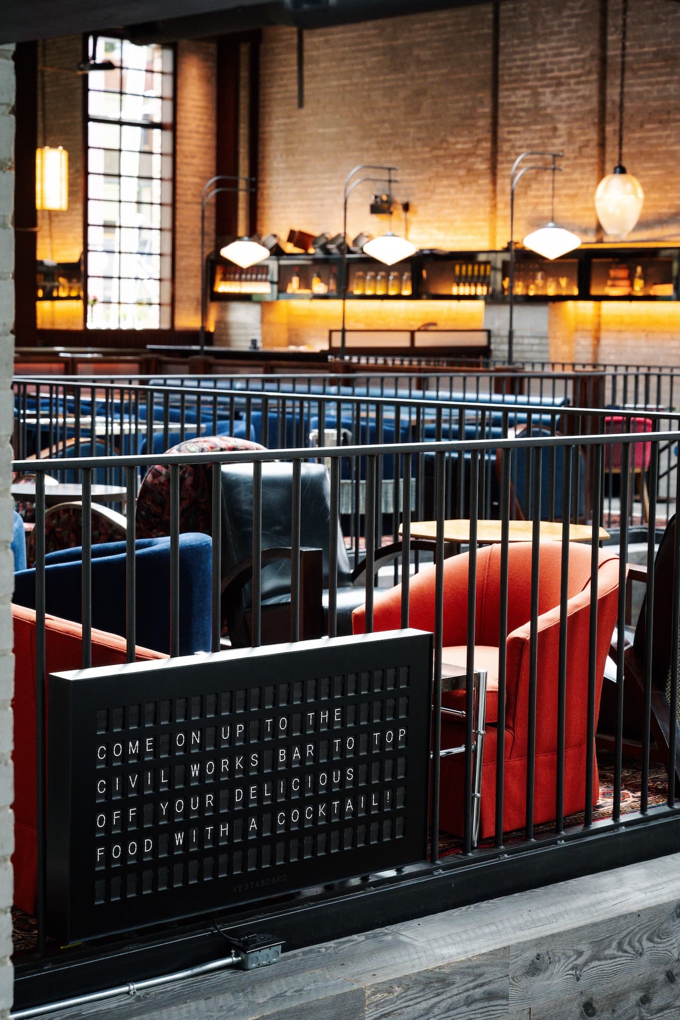 View of Civil Works seating area featuring the rod iron railings and the hanging lights.