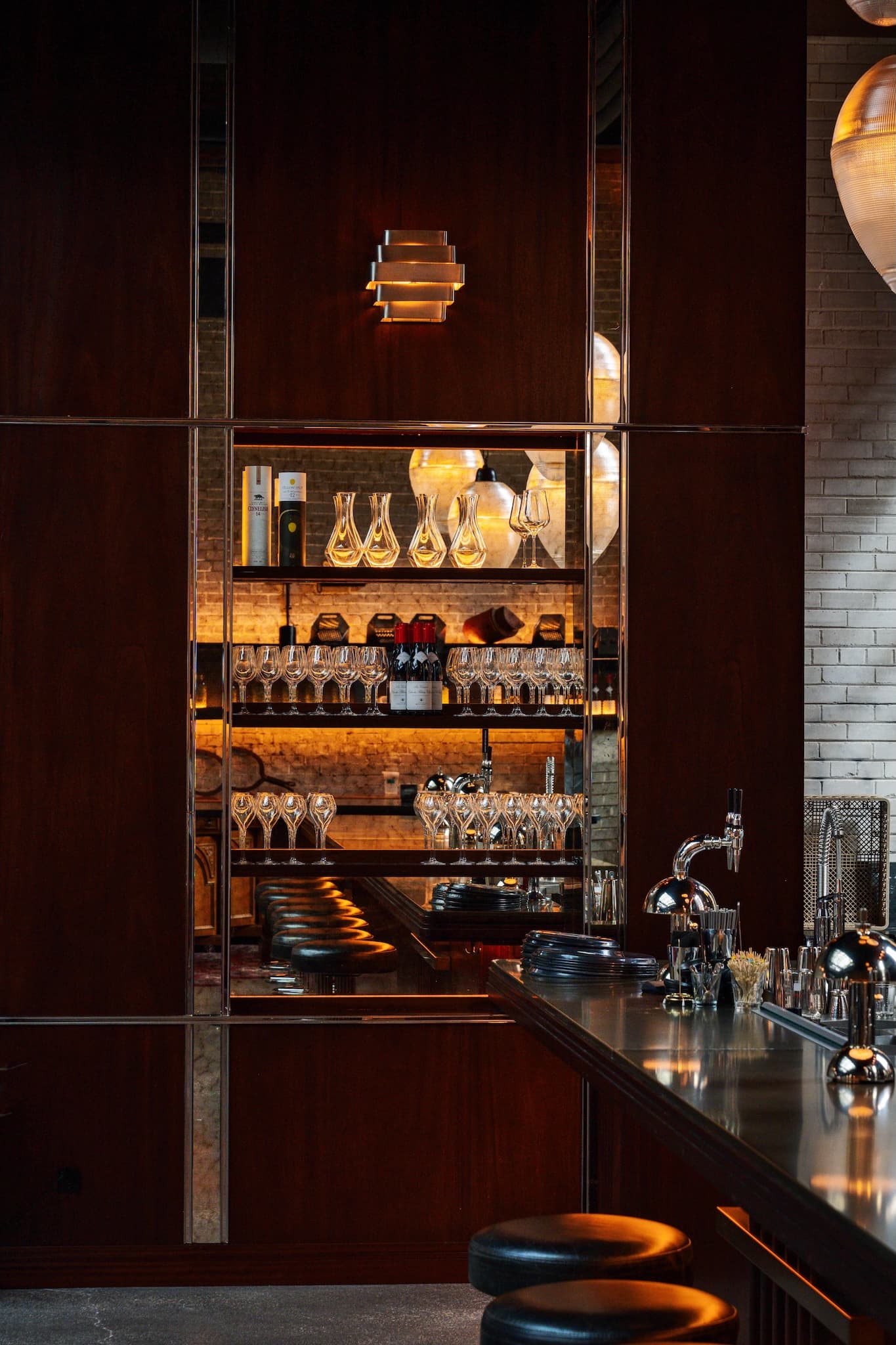 Back-lit shelves containing wine glasses at the Civil Works Bar