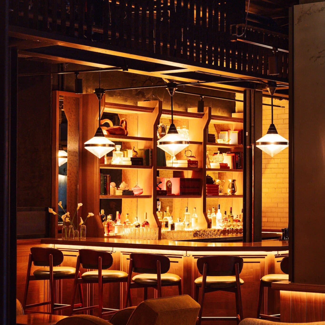 View of the built-in bar and leather high-tops that surround it.