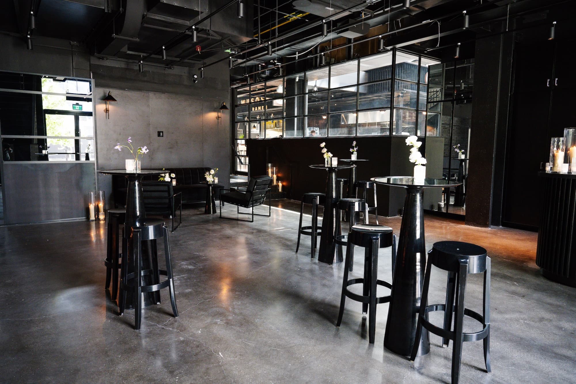 Reception room of the event hall set up for a cocktail reception showing black cruiser tables and stools.